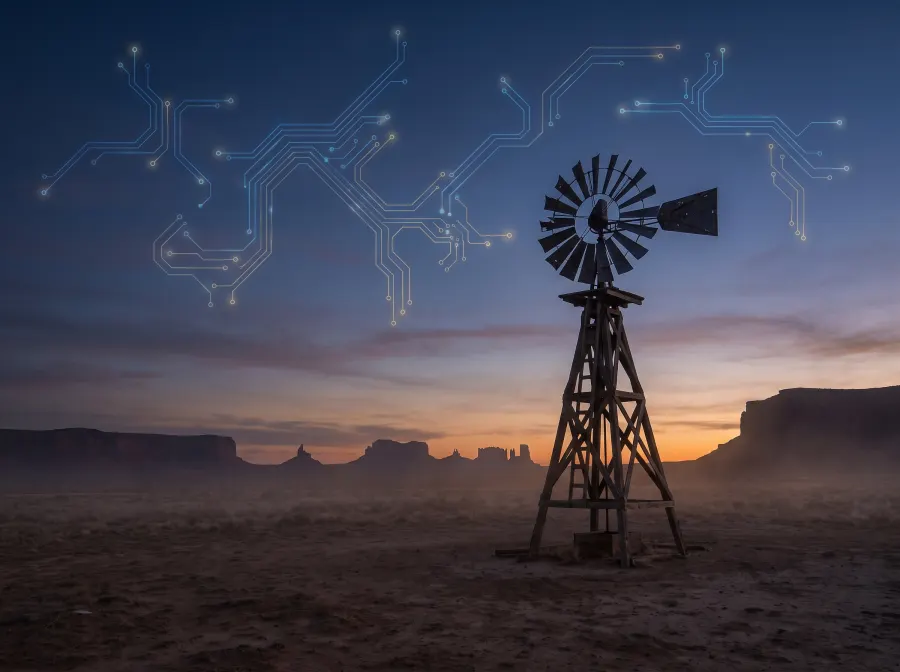 A frontier windmill turning at dusk